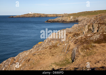 Wales Küstenweg in Nord-Wales. Nord-Küste von Anglesey mit Lynas Point Leuchtturm im Hintergrund. Stockfoto