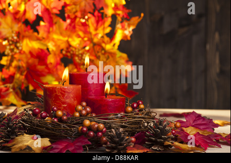 Kerzen in schöne bunte Herbstblätter Stockfoto