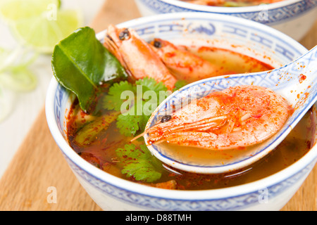 Tom Yum Goong - Thai klar scharf-saure Suppe mit König Garnelen und Austernpilzen mit Limettenscheiben serviert. Stockfoto