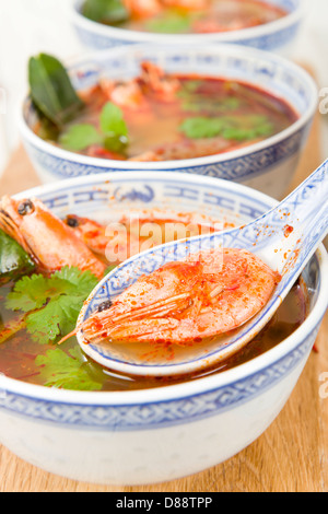 Tom Yum Goong - Thai klar scharf-saure Suppe mit König Garnelen und Austernpilzen mit Limettenscheiben serviert. Stockfoto