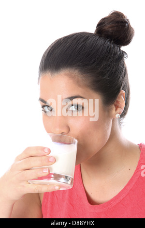 Junge Dunkelhaarige europäische Frau Holding und trinkt ein Glas frische, gesunde Milch gegen einen weißen Hintergrund mit Haaren in einem Brötchen gebunden Stockfoto