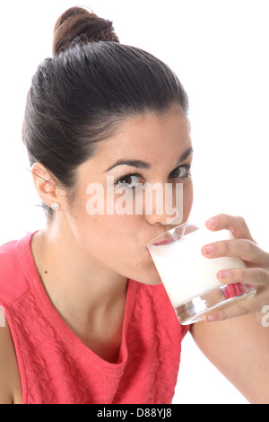 Junge Dunkelhaarige europäische Frau Holding und trinkt ein Glas frische, gesunde Milch gegen einen weißen Hintergrund mit Haaren in einem Brötchen gebunden Stockfoto
