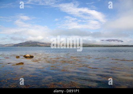 Loch-Flotte, Schottland. Loch-Flotte mit einer Wolke bedeckt Balblair Wood, Hügel und Silver Rock im Hintergrund. Stockfoto