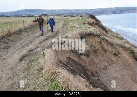 Mann und Frau zu Fuß entlang des Cleveland-Weg in der Nähe von Ravenscar, North York Moors, England uk Stockfoto