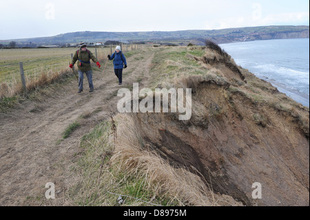 Mann und Frau zu Fuß entlang des Cleveland-Weg in der Nähe von Ravenscar, North York Moors, England uk Stockfoto