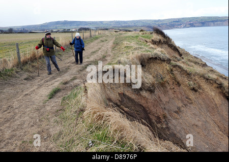 Mann und Frau zu Fuß entlang des Cleveland-Weg in der Nähe von Ravenscar, North York Moors, England uk Stockfoto