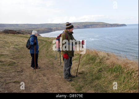 Mann und Frau zu Fuß entlang des Cleveland-Weg in der Nähe von Ravenscar, North York Moors, England uk Stockfoto