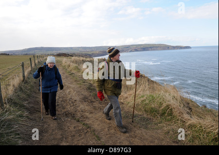 Mann und Frau zu Fuß entlang des Cleveland-Weg in der Nähe von Ravenscar, North York Moors, England uk Stockfoto