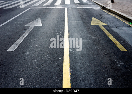 Weißer und gelber Pfeil auf der Straße Stockfoto