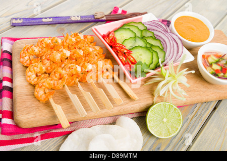 Goong - Thai Garnelen Satay mit Erdnuss-Sauce, Gurke und Zwiebel-Relish zu stillen. Beilage von Gurken, roten Zwiebeln und Chili. Stockfoto