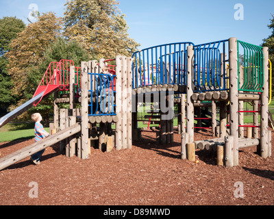 Kinder spielen auf einem Klettern Rahmen und schieben Spielplatz von Golders Hill Park, North West London Stockfoto