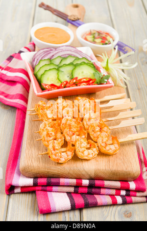 Goong - Thai Garnelen Satay mit Erdnuss-Sauce, Gurke und Zwiebel-Relish zu stillen. Beilage von Gurken, roten Zwiebeln und Chili. Stockfoto