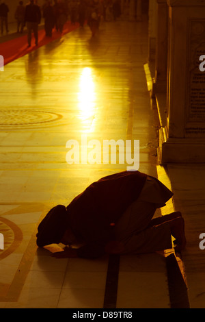 Amritsar Punjab, Indien. Golden Temple Silhouette des männlichen beten am Eingang bei Sonnenaufgang Stockfoto