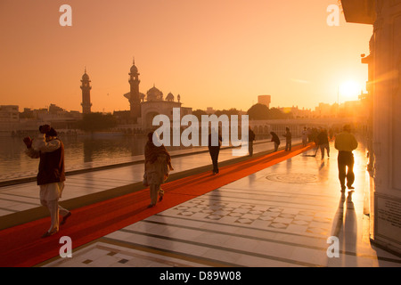 Indien, Punjab, Amritsar, Sikh-Pilger zu Fuß rund um den goldenen Tempel bei Sonnenaufgang Stockfoto