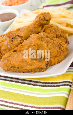 Fried Chicken & Chips - Hähnchenteile auf den Knochen in würziger Mehl überzogen und frittiert. Pommes frites, Bohnen und Soße Seiten. Stockfoto