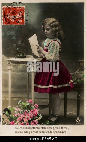 Das kleine Mädchen schreibt einen Brief an ihre Oma Stockfoto