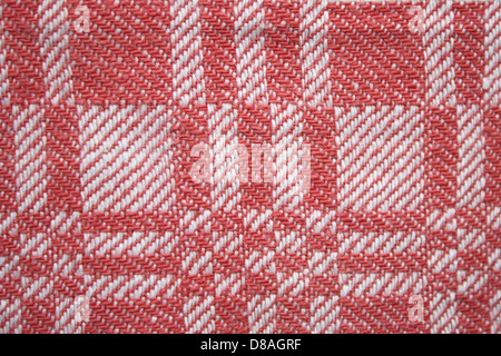 Nahaufnahme eines gewebten Stoffes in Rot und weiß mit quadratischem Muster. Die Struktur und das Muster des Materials verleihen ihm einen dynamischen Look, perfekt für Textildesign oder Modematerialien. Stockfoto