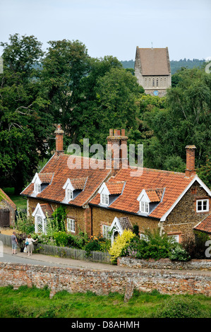 Aus rotem Backstein Hütten mit Gauben und Gärten und St. Laurentius-Kirche im Dorf von Castle Rising, Norfolk, England Stockfoto