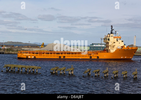 Eine große orange Schiff im Hafen von Leith in der Nähe von Edinburgh in Schottland mit einem Hügel direkt hinter dem Schiff Stockfoto