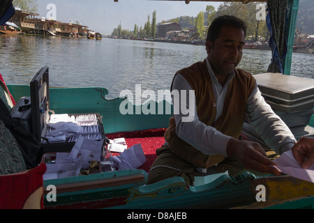 Kashmiri Mann verkaufen künstliche Schmuck aus einem anderen Shikara im Dal-See, wir werden auf einer Shikara und er auf einem anderen Stockfoto