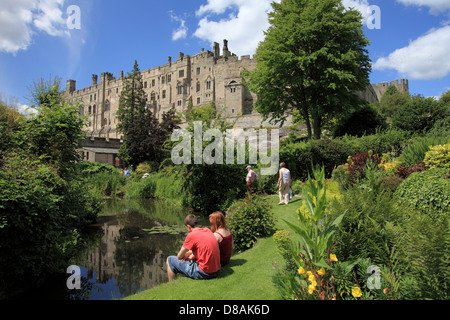 Touristen genießen die Gärten unter Warwick Castle am Ende des Mill Street, Schlossmühle und den Mühlenteich Stockfoto