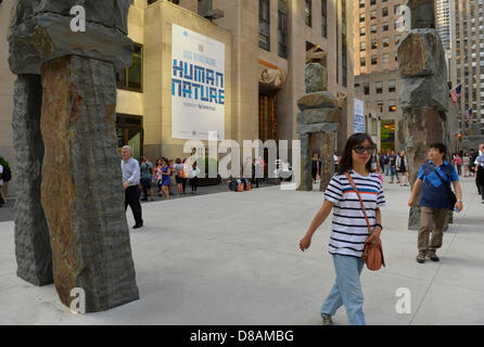 New York, USA. 21. Mai 2013. Besucher sind Fuß durch die Natur des Menschen, eine Outdoor-Kunstinstallation von Künstler Ugo Rondinone, speziell für seine Lage vor 30 Rockefeller Plaza und verfügt über neun kolossalen Strukturen. Der 16-Fuß, 20-Fuß hohen menschlichen geformte Steinfiguren bestehen aus rund geformte Platten aus Blaustein und jeweils bis zu 30.000 Pfund wiegen. Dieser kostenlose Ausstellung, präsentiert von Nesporesso und organisiert von Public Art Fund und Tishman Speyer, ist zu sehen bis 7. Juli 2013. Bildnachweis: Ann E Parry / Alamy Live News Stockfoto