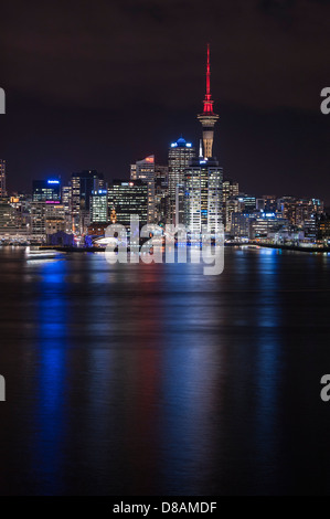 Die Lichter der Innenstadt von Auckland, CBD und Sky Tower reflektieren über den Hafen in der Nacht. Neuseeland Stockfoto