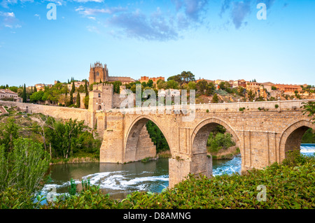 Wunderschöne Landschaft von Toledo in Spanien. Steinerne Brücke in ruhiger Fluss. Blaue Himmel spiegelt sich im kristallklaren Wasser. Große Festung Stockfoto
