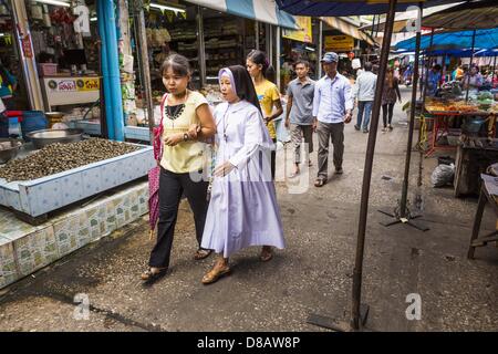 23. Mai 2013 - Mae Sot, Tak, Thailand - A katholische Nonne und ein Freund gehen durch den burmesischen Markt in Mae Sot, Thailand. Fünfzig Jahre der politischen Unruhen in Burma (Myanmar) hat Millionen von Burmesen ihr Land verlassen geführt. Viele haben im benachbarten Thailand niedergelassen. Mae Sot, an der Mae Nam Moie (Moie River) ist das Zentrum der birmanischen Exil lebende Gemeinschaft im zentralen Westen Thailands. Es gibt Hunderte von Tausenden von burmesischen Flüchtlingen und Migranten im Bereich. Viele Leben ein Schattendasein ohne Papiere und ohne Rückgriff, wenn sie die thailändische Behörden überqueren. Die Burmesen haben ihre eigenen Schulen und Stockfoto