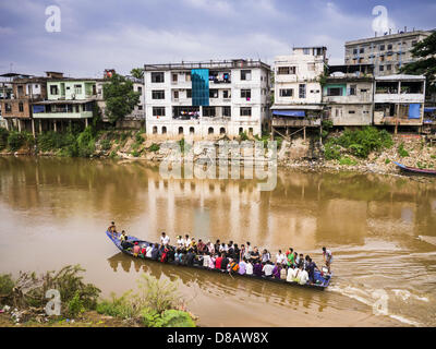 23. Mai 2013 - Mae Sot, Tak, Thailand - Burma Cram in ein großes Boot und schweben über den Fluss Moie nach Thailand. MYAWADDY ist im Hintergrund. Fünfzig Jahre der politischen Unruhen in Burma (Myanmar) hat Millionen von Burmesen ihr Land verlassen geführt. Viele haben im benachbarten Thailand niedergelassen. Mae Sot, an der Mae Nam Moie (Moie River) ist das Zentrum der birmanischen Exil lebende Gemeinschaft im zentralen Westen Thailands. Es gibt Hunderte von Tausenden von burmesischen Flüchtlingen und Migranten im Bereich. Viele Leben ein Schattendasein ohne Papiere und ohne Rückgriff, wenn sie die thailändische Behörden überqueren. Die burmesischen h Stockfoto