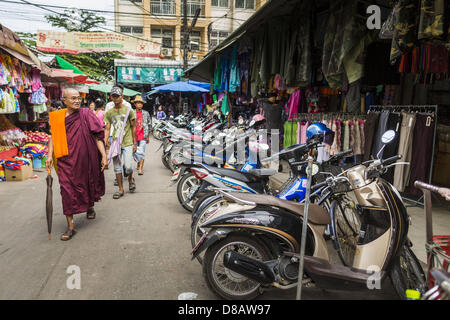 23. Mai 2013 - Mae Sot, Tak, Thailand - A birmanischen buddhistischen Mönch Spaziergänge durch burmesischen Markt in Mae Sot, Thailand. Fünfzig Jahre der politischen Unruhen in Burma (Myanmar) hat Millionen von Burmesen ihr Land verlassen geführt. Viele haben im benachbarten Thailand niedergelassen. Mae Sot, an der Mae Nam Moie (Moie River) ist das Zentrum der birmanischen Exil lebende Gemeinschaft im zentralen Westen Thailands. Es gibt Hunderte von Tausenden von burmesischen Flüchtlingen und Migranten im Bereich. Viele Leben ein Schattendasein ohne Papiere und ohne Rückgriff, wenn sie die thailändische Behörden überqueren. Die Burmesen haben ihre eigenen Schulen und Kra Stockfoto