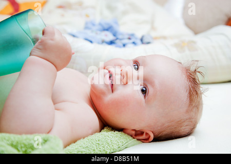 Ein Baby verändert seine Serviette warten auf Bett liegend Stockfoto