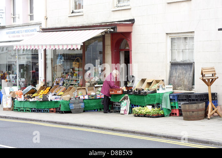 Eine alte Dame kaufen Obst aus den Displays vor einem Geschäft in Thornbury in Gloucestershire, England, UK. Mai 2013 Stockfoto