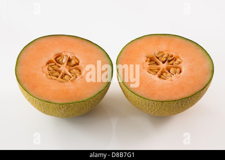 Leckere süße Melone schneiden Sie in zwei, auf weißem Hintergrund. Stockfoto