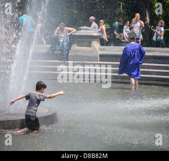 Ein Absolvent der New York University in ihrer Mütze und Mantel Posen in den Brunnen im Washington Square Park in Greenwich Village in New York Stockfoto