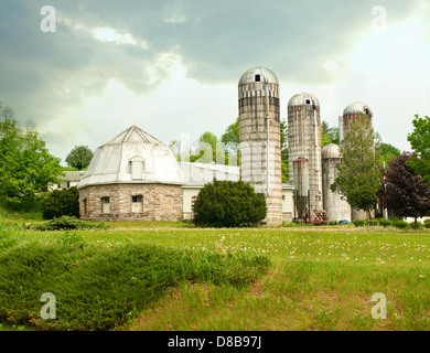 Bauernhof mit Scheune und Silos an einem bewölkten Frühlingstag Stockfoto