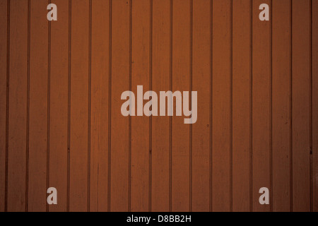 Ein detailliertes Bild der braunen vertikalen Seitenverkleidung, das die glatte Textur und das konsistente Muster der Dielen zeigt. Das Bild konzentriert sich auf die gleichmäßigen Linien und die natürlichen Holztöne, die charakteristisch für Wohn- oder Gewerbeflächen sind. Stockfoto