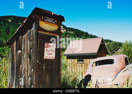 Alten Nebengebäude mit No Parking und "Gezeigt durch Ernennung nur" Zeichen angebracht, mit verlassenen rostige Auto in der Nähe in Silver City, ID Stockfoto