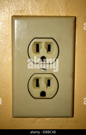 Eine Nahaufnahme einer normalen Steckdose. Die Abbildung zeigt die beiden Stecker und die Erdungsbohrung, was das praktische Design dieses Haushaltsartikels unterstreicht. Stockfoto
