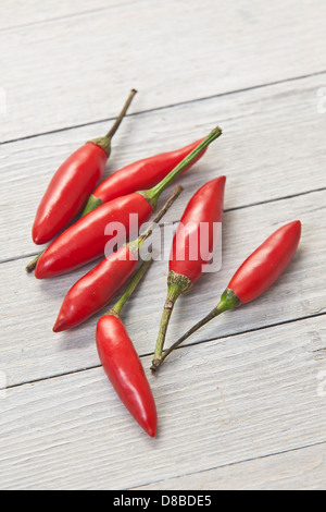 Sieben rote Thai-Chilischoten auf rustikale Oberfläche des Holzes. Stockfoto