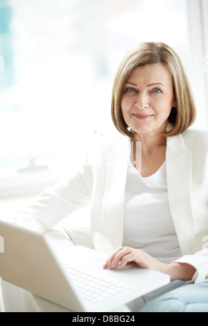 Porträt von Reife Frau mit Laptop, Blick in die Kamera Stockfoto
