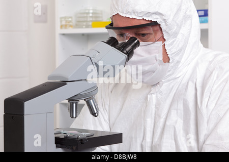 Eine männliche Laborantin in sterile Kleidung Blick durch das Okular des Mikroskops. Stockfoto