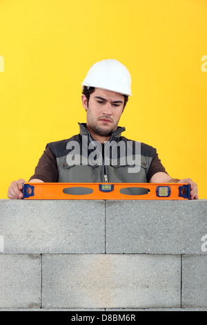 Maurer mit einer Wasserwaage Stockfoto