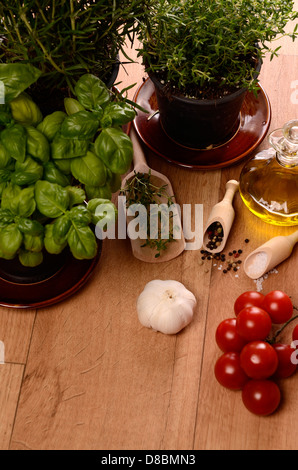 Verschiedene Kräuter und Kochzutaten auf einem hölzernen Hintergrund Stockfoto