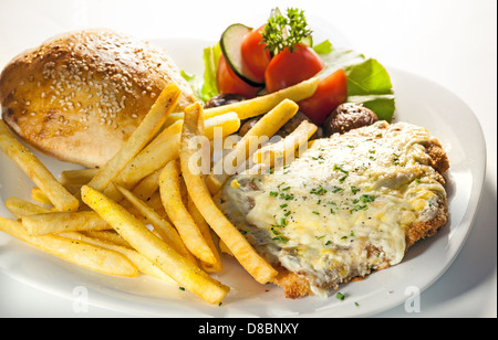 Stück von gebratenem Fleisch und Pommes Frites auf weißen Teller, Studio isoliert. Stockfoto