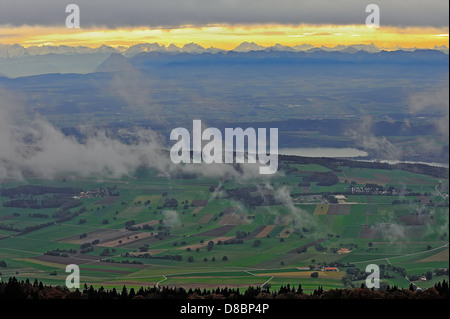 Schweizer Alpen vom Chasseral gesehen Gipfel an einem bewölkten Tag in goldenes Licht Stockfoto