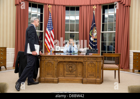 US-Präsident Barack Obama spricht am Telefon mit FBI-Direktor Robert Mueller, kurz nachdem der zweite Verdächtige in den Boston-Marathon Bombenanschläge 19. April 2013 in Washington, DC im Oval Office des weißen Hauses gefangen genommen wurde. Chef des Stabes Denis McDonough hört sich in der Nähe. Stockfoto