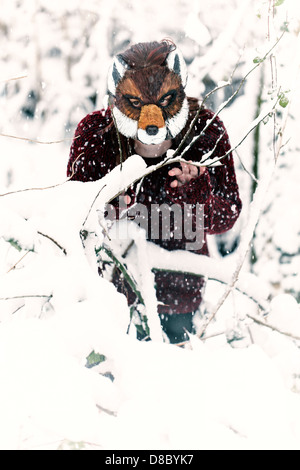 Frau trägt eine Maskierung Fuchs im Schnee Stockfoto