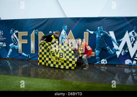 London, UK. 24. Mai 2013. Borussia Dortmund Fans entrollen einen Team Banner vor dem Champions-League-Plakat. Ein Fan-Park auf dem Trafalgar Square wurde eingerichtet, gerecht zu werden für die Tausenden von ticketless deutschen Fans von Borussia Dortmund und Bayern München erwartet für 2013-Champions-League-Finale im Wembley-Stadion zu kommen. Bildnachweis: Amer Ghazzal / Alamy Live News Stockfoto