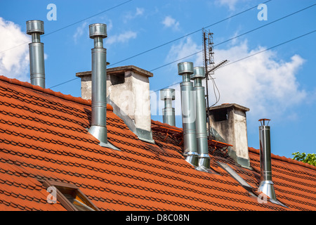 Schornsteine auf dem Dach des Gebäudes vor blauem Himmel. Stockfoto